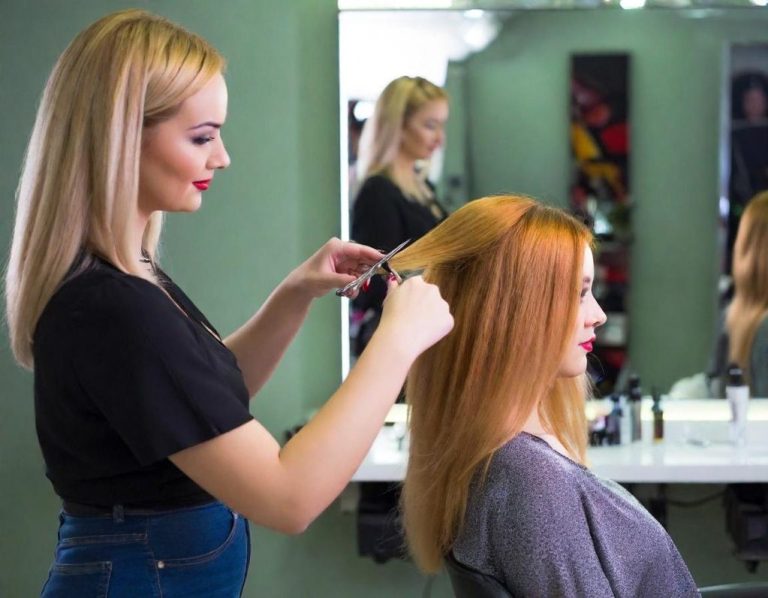 Friseurin schneidet das Haar einer Kundin in einem modernen Salon.